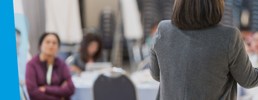 Woman speaking to a teacher audience at a talk.