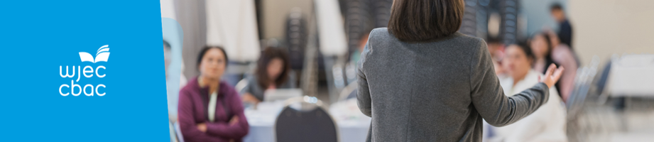 Woman speaking to a teacher audience at a talk.