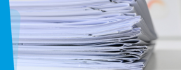 Stack of exam papers on a desk.
