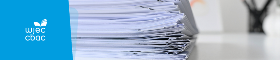 Stack of exam papers on a desk.